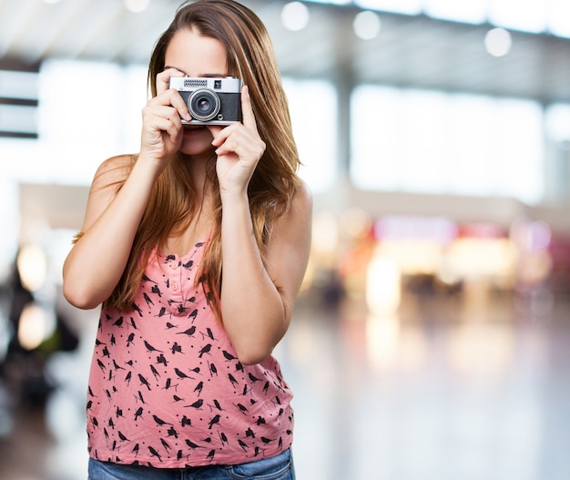 молодая женщина, держащая старинный фотоаппарат