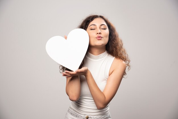 young woman holding white handmade paper heart. high quality photo