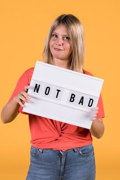 Free photo young woman holding white light box with not bad text