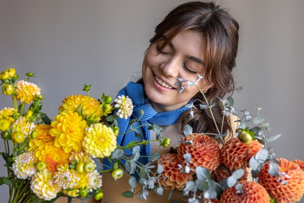 A young woman holds a bouquet of chrysanthemums flowers