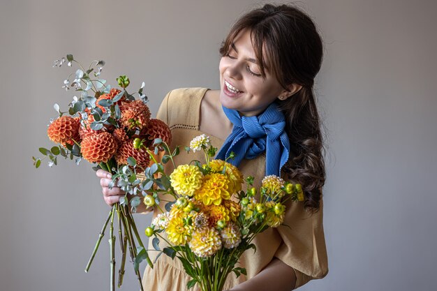 A young woman holds a bouquet of chrysanthemums flowers.