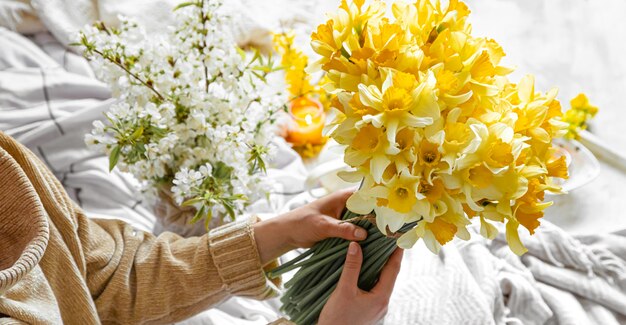 young woman holds a bouquet of daffodils.