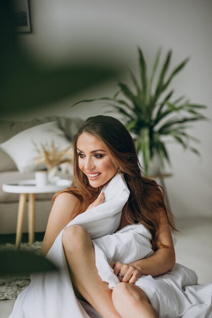 Young woman at home covered in blanket