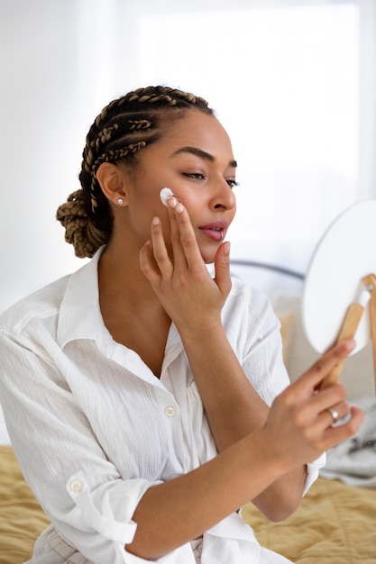 Foto gratuita giovane donna a casa che fa la sua routine di bellezza