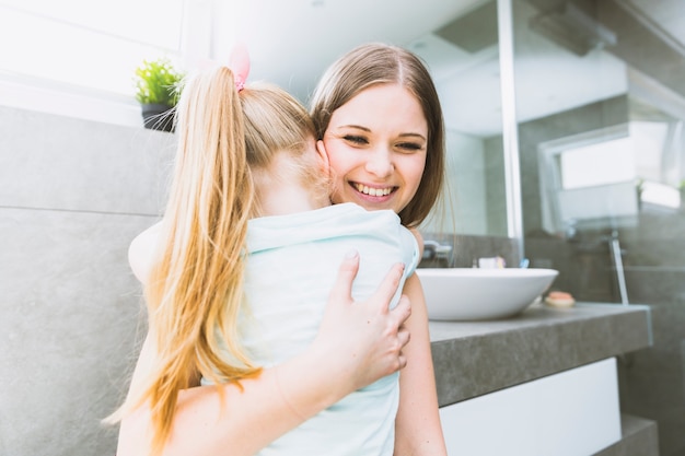 Young woman hugging daughter