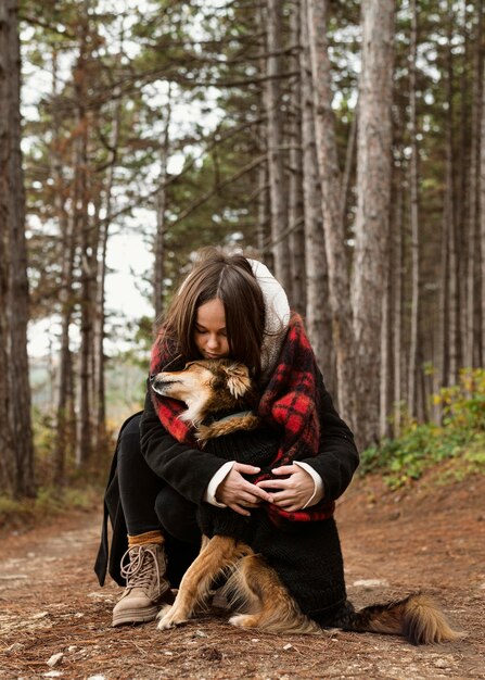 森の中で犬を抱き締める若い女性