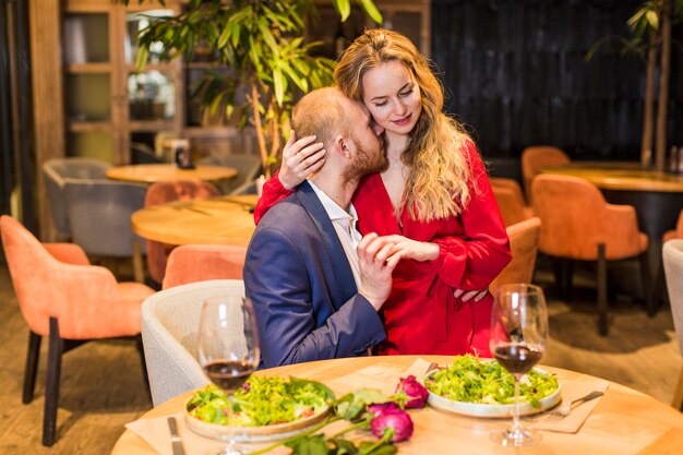 Young woman hugging man at table 