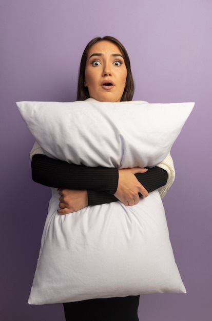 Free photo young woman hugging pillow confused and worried