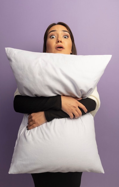 Free photo young woman hugging pillow worried and confused