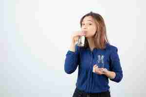 무료 사진 물 한 잔을 마시는 파란색 블라우스에 젊은 여자.