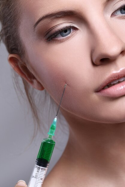 Young woman injecting for a beauty treatment