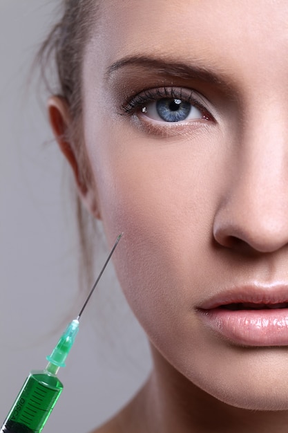 Young woman injecting for a beauty treatment