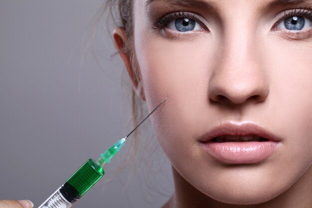 Young woman injecting for a beauty treatment