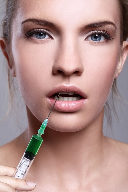 Free photo young woman injecting for a beauty treatment