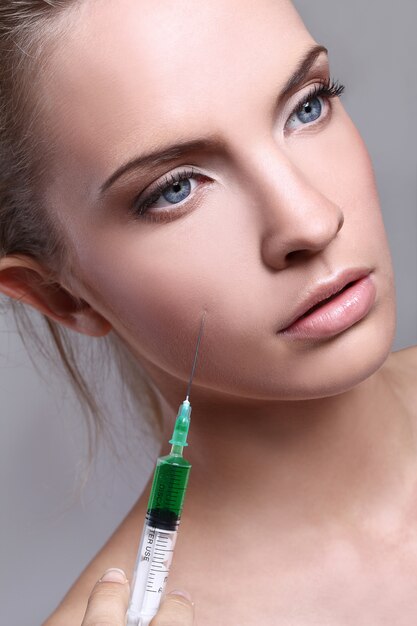 Young woman injecting for a beauty treatment