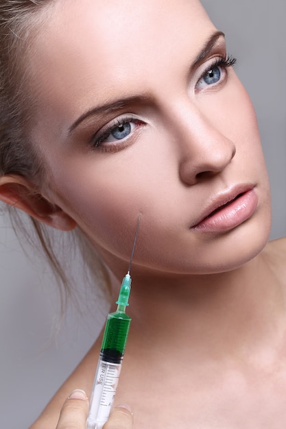 Young woman injecting for a beauty treatment