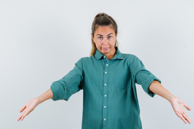 Free photo young woman inviting to come in green blouse and looking cute