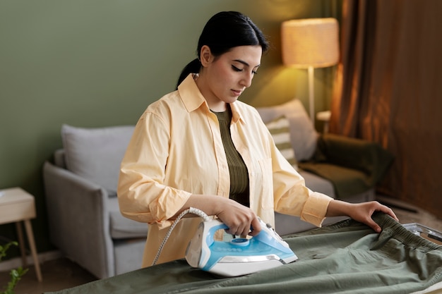 Young woman ironing at the living room