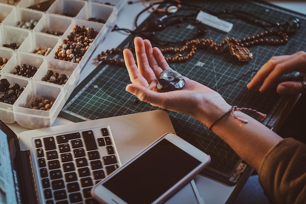 Free photo young woman is holding ancient shell while sitting at her workplace.