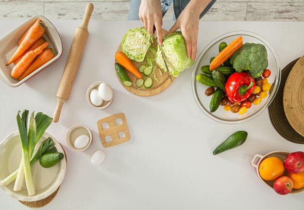 young woman is preparing a salad in the kitchen .