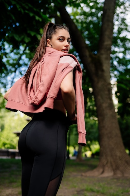 Foto gratuita la giovane donna sta riposando dopo aver fatto jogging nel parco.