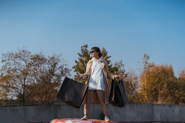 免費 Photo 一位年輕的女人站在車裡,手裡拿著袋子