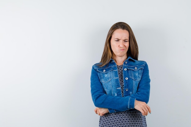 The young woman is thinking by looking down  on white background