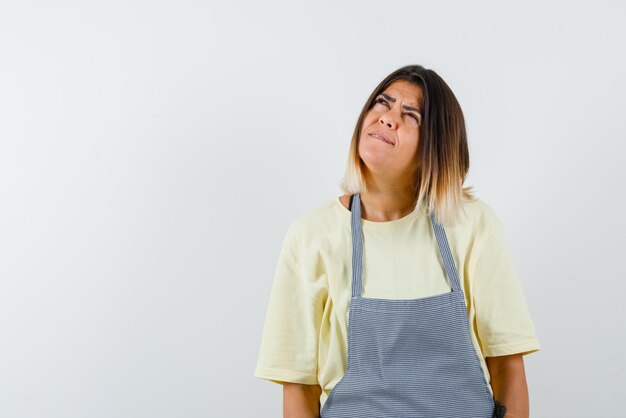 The young woman is thinking by looking up on white background