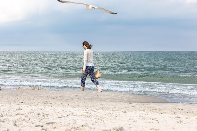 젊은 여자가 바다를 걷고 있다