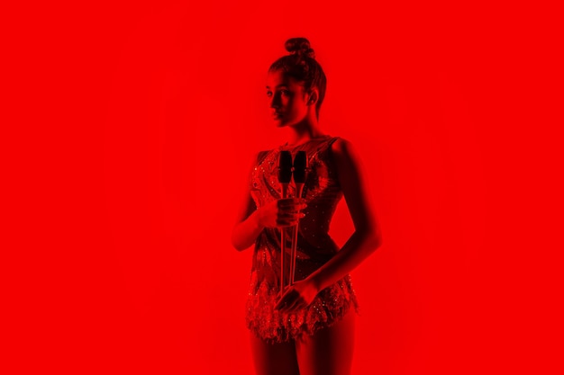 赤いスタジオの壁に孤立した若い女性