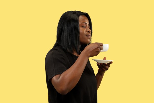 Young woman isolated on yellow studio wall