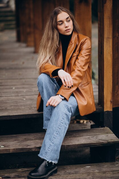 Young woman in jacket sitting on stairs