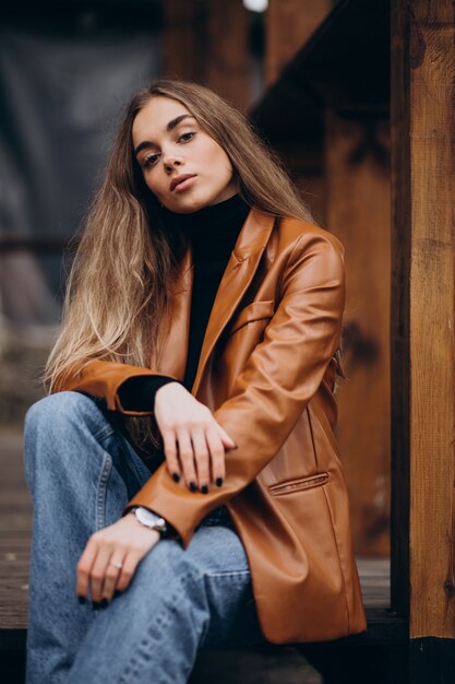 young woman in jacket sitting on stairs