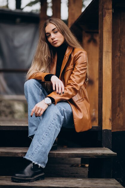 Young woman in jacket sitting on stairs