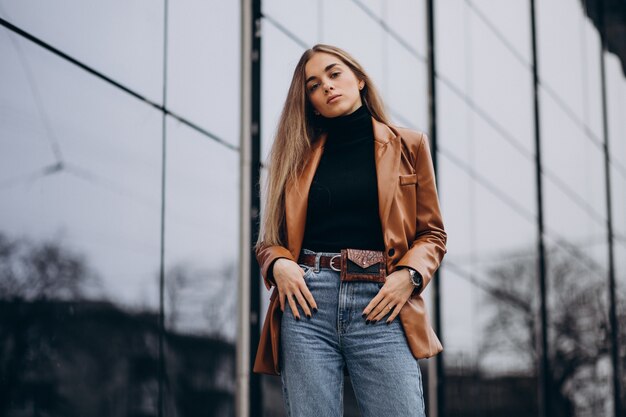 Young woman in jacket walking out in the city