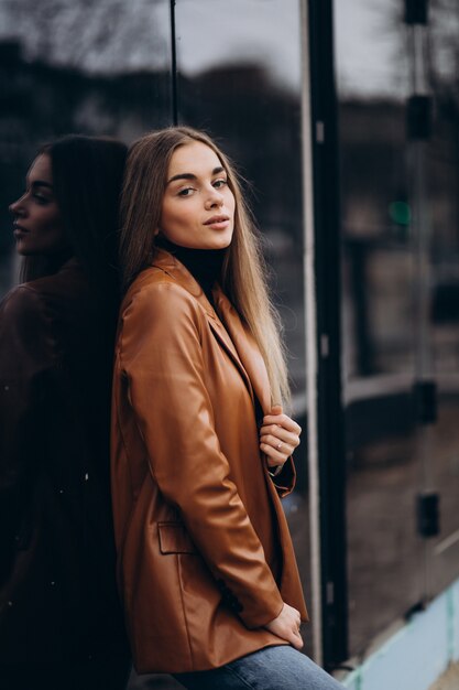 Young woman in jacket walking out in the city