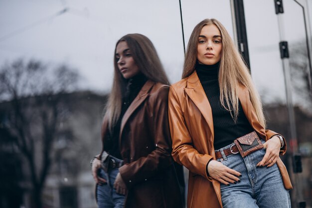 Young woman in jacket walking out in the city