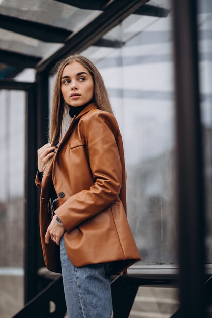 young woman in jacket walking out in the city