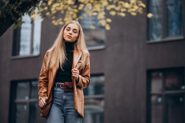 Young woman in jacket walking out in the city