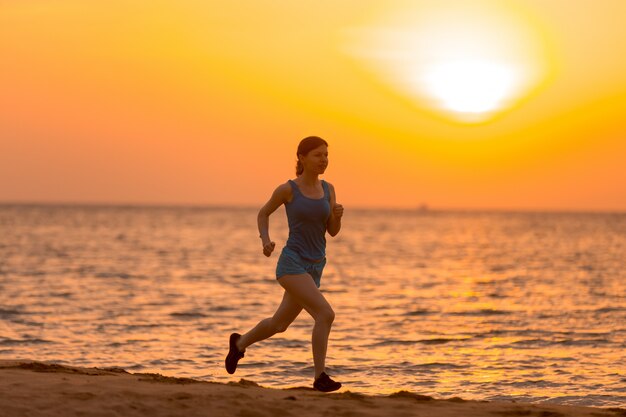 日の出、ジョギングする若い女性