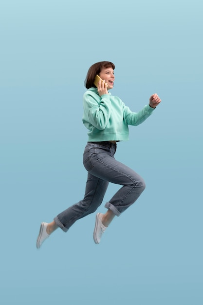 Young woman jumping isolated on blue