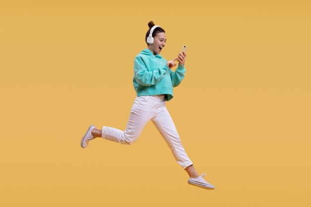 Young woman jumping isolated on orange