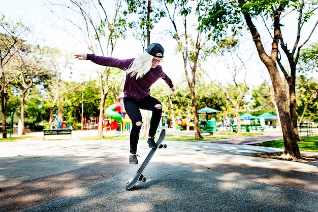 Молодая женщина прыгает Olly Скейтборд концепции
