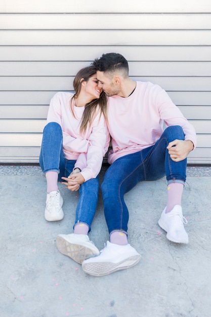 Young woman kissing and holding hands with handsome man