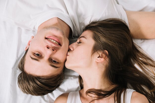 Young woman kissing man on cheek 