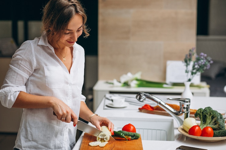 無料Photo 朝食を調理するキッチンで若い女性