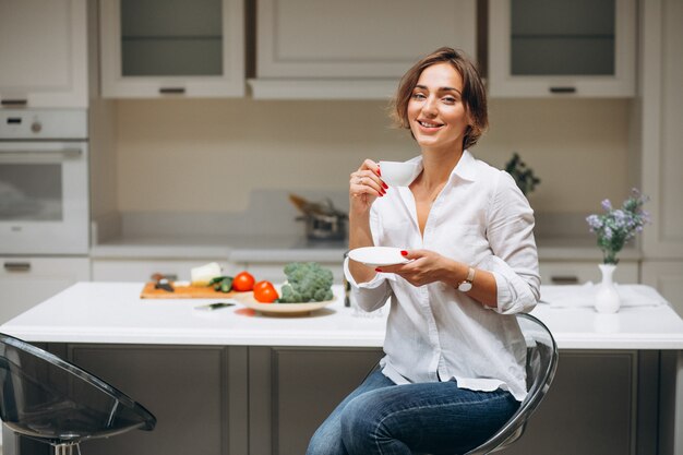 Young woman at kitchen drinking coffee in the morning