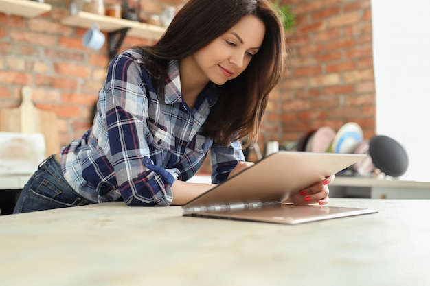 Young woman in the kitchen using digital tablet.