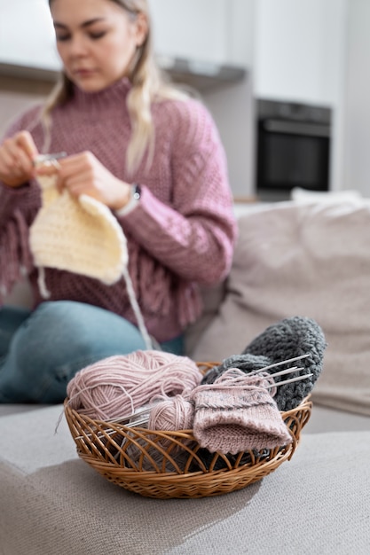 Giovane donna che lavora a maglia mentre ci si rilassa