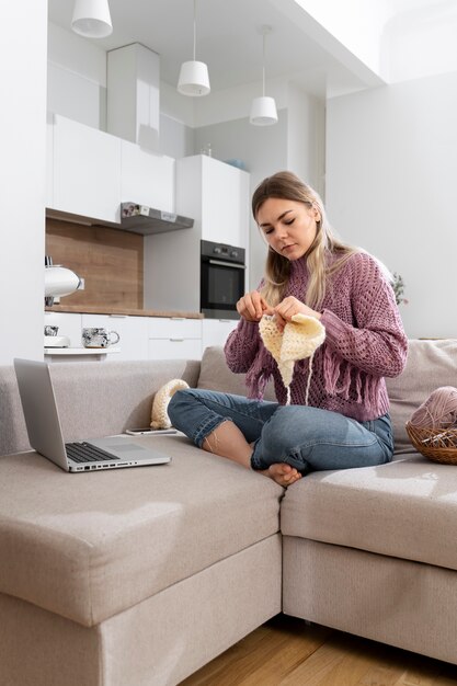 Young woman knitting while relaxing